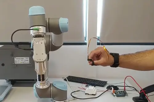 Robot colaborativo para automatización industrial manejado por sensores IoT Brazo robot siendo manejado por una persona en un laboratorio de robótica colaborativa